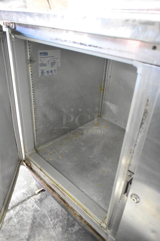 McCall PTA-3 stainless steel pizza prep table, 115V, 1 phase, with commercial casters. Interior label visible. Used condition.