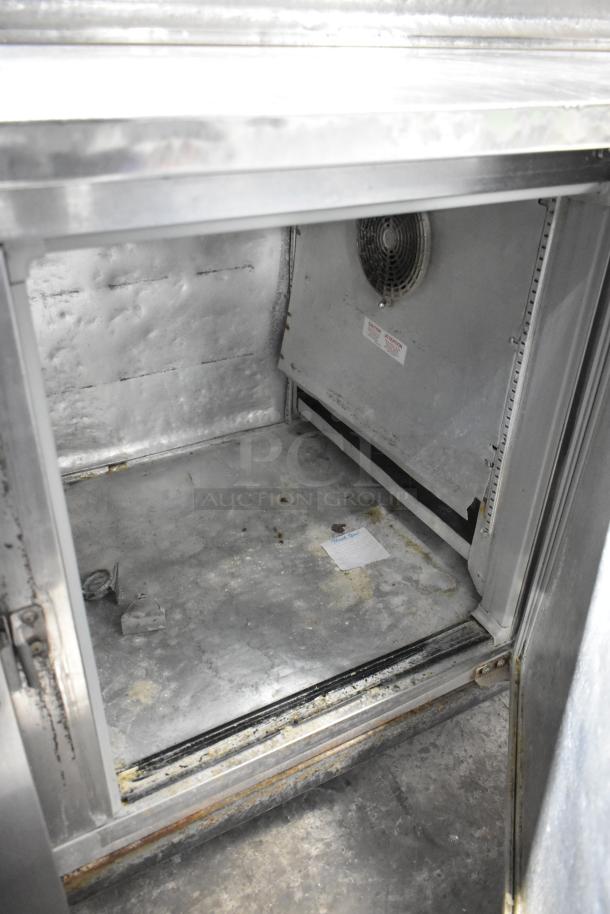 McCall PTA-3 stainless steel commercial pizza prep table interior, showing fan and storage space. Well-used condition.