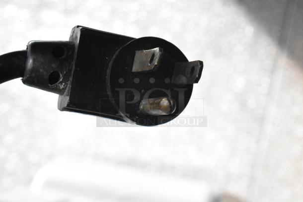 A close-up of a power plug associated with a True TUC-60 stainless steel commercial undercounter cooler.