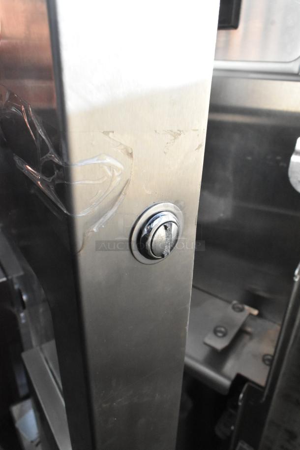 JBT 2 GEN MFJ Fresh N Squeeze stainless steel citrus juicer detail, showing exterior finish and lock, on commercial casters.