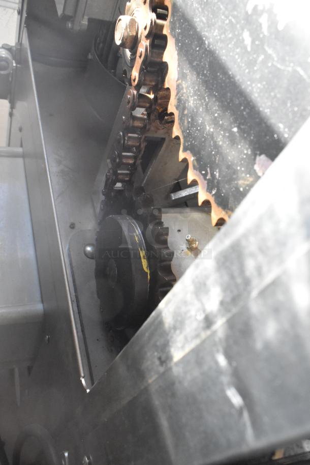 LATE MODEL JBT 2 GEN MFJ Fresh N Squeeze citrus juicer. Stainless steel, commercial casters, visible chain mechanism.