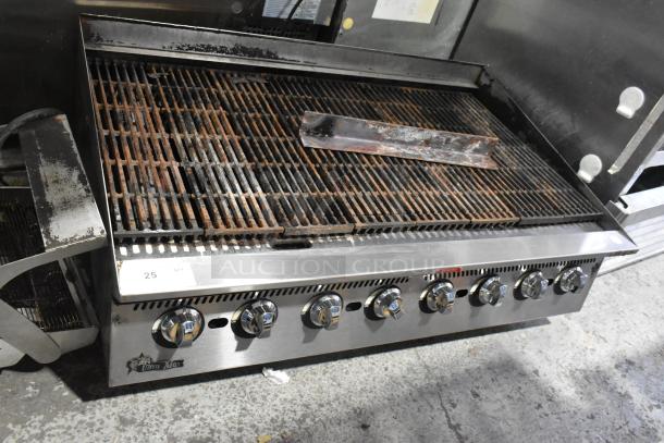 Star Ultra Max stainless steel commercial countertop gas charbroiler grill, featuring six control knobs, showing signs of use.