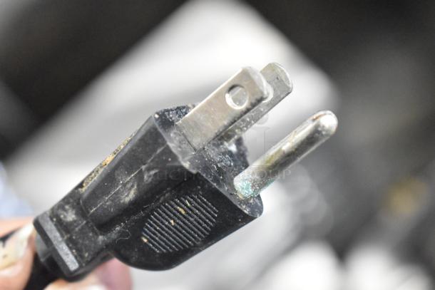 Black electrical plug for Crathco D25-3 beverage machine, 115 volts, 1 phase, showing signs of wear.