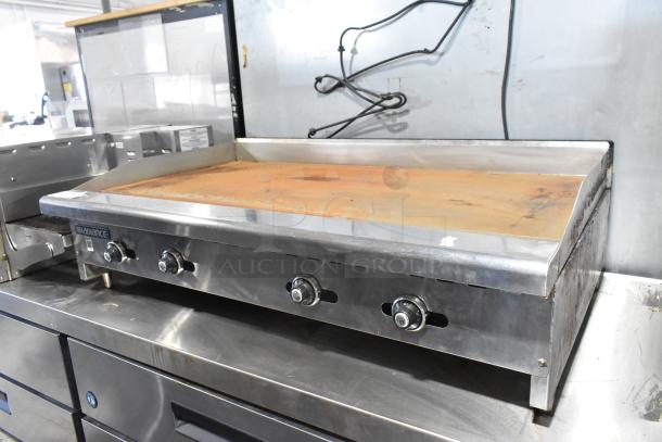 Radiance stainless steel commercial gas griddle, flat top, 3 knobs, worn condition, visible brown rust on surface.
