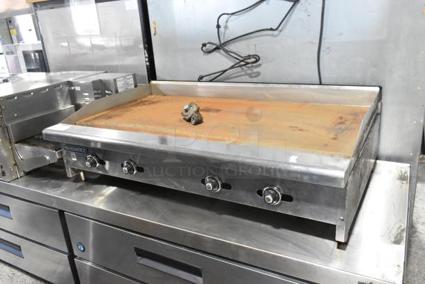 Radiance stainless steel commercial gas griddle, flat top, visible wear, 4 control knobs, countertop model.