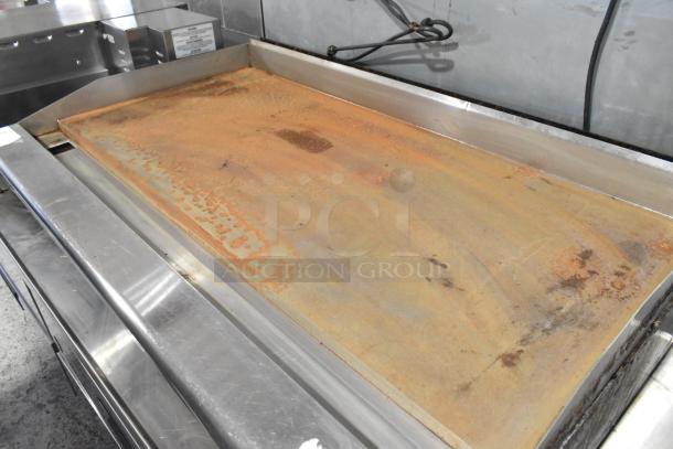 Radiance stainless steel gas-powered flat top griddle, countertop model. Visible wear and rust. Ideal for commercial use.