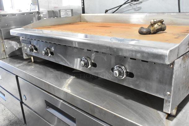 Radiance stainless steel commercial gas griddle with four control knobs, good condition, flat top surface, slightly worn.
