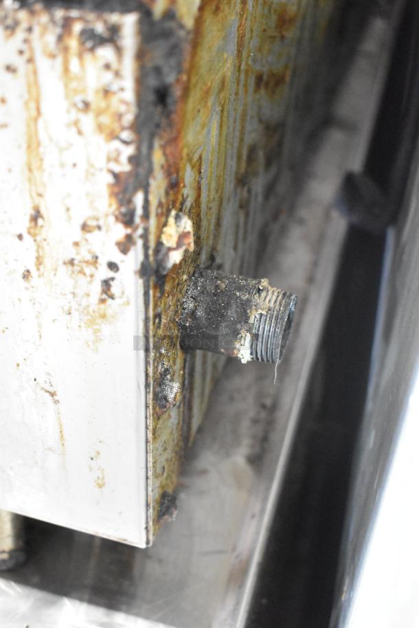 Rusty Radiance stainless steel commercial gas griddle, visible corrosion and wear on gas connector.