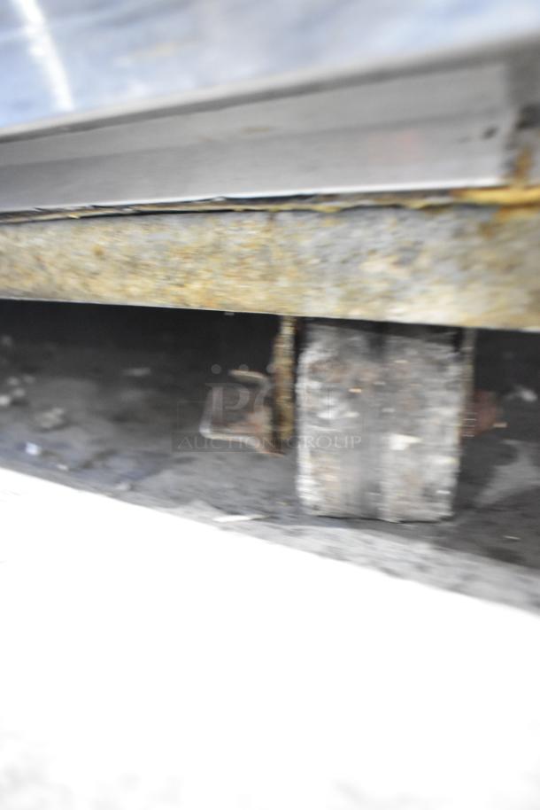 Hoshizaki stainless steel 4-drawer chef base on commercial casters, 115V, 1 phase, showing caster detail, some rust visible.