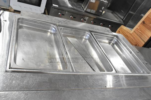 Turbo Air JBT-48-N stainless steel refrigerated buffet table, showing surface wear. Includes three compartments and commercial casters.