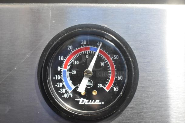 Gauge with "True" logo on a stainless steel panel, displaying temperatures from -40°F to 65°F in red, white, and blue.