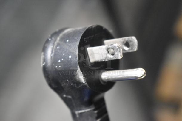 Close-up of a three-prong plug of the True GDM-12-HC cooler, compatible with 115 volts, 1 phase power.