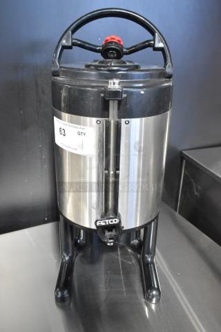 Fetco stainless steel beverage holder dispenser with black handle, visible tap, and item tag, in good condition.