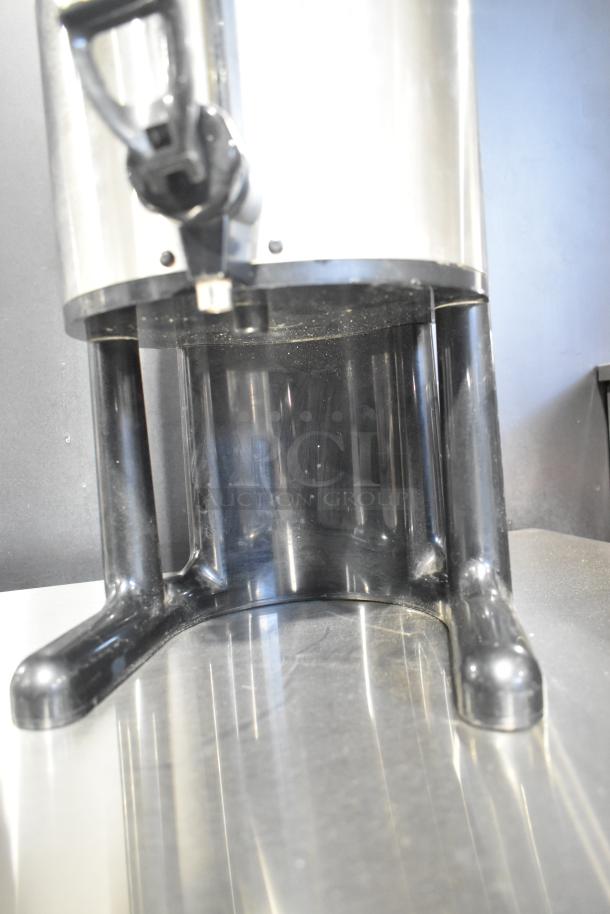 Fetco Stainless Steel Beverage Dispenser, durable construction, good condition, with a sturdy black base and dispensing spout.