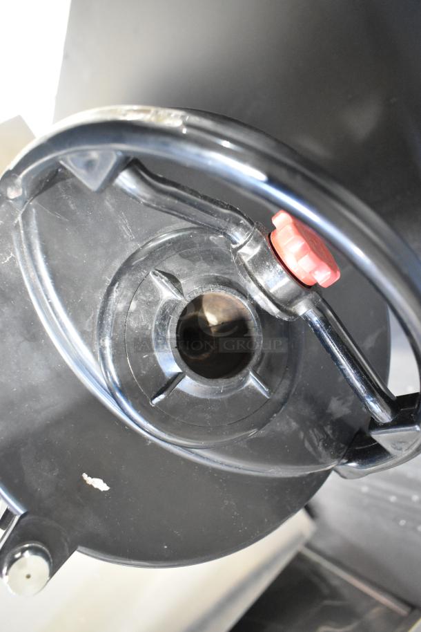 Fetco stainless steel beverage holder dispenser, featuring a black lid with a red knob. Used condition, with minor wear.