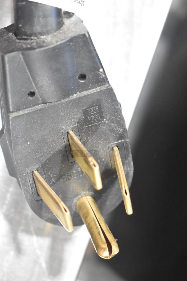 Close-up of a power plug from a Hobart LXe Stainless Steel Commercial Undercounter Dishwasher, showing prongs and slight wear.