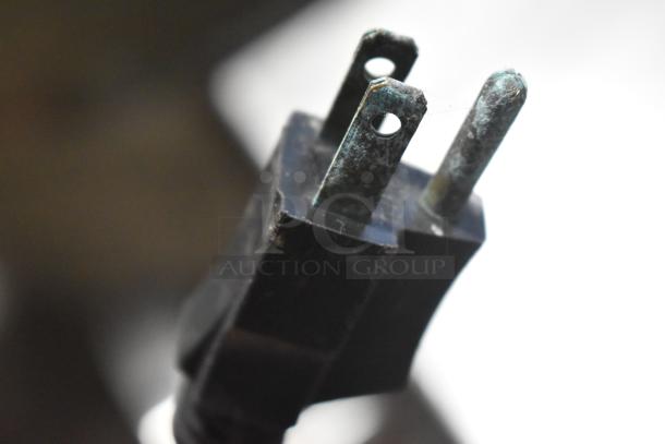 Close-up of a three-prong plug with slight corrosion, likely used for the Cleveland KGL-40-T steam kettle.