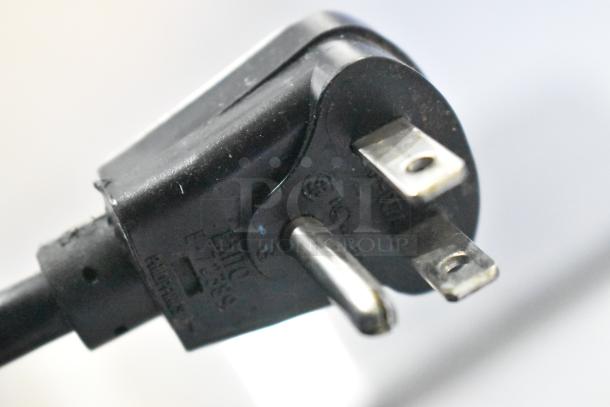 Close-up of a black electrical plug for a Scotsman HID312A-1A ice machine. Plug features standard three-prong design.