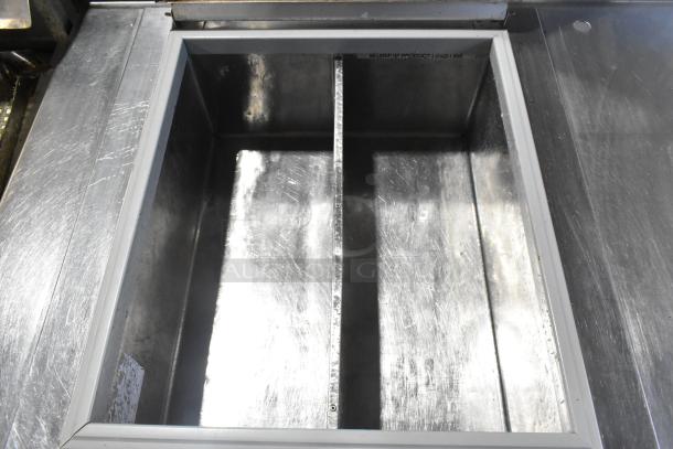 Stainless steel commercial work table with drop-in compartment. Features 115 volts, 1 phase. Sturdy, used condition.