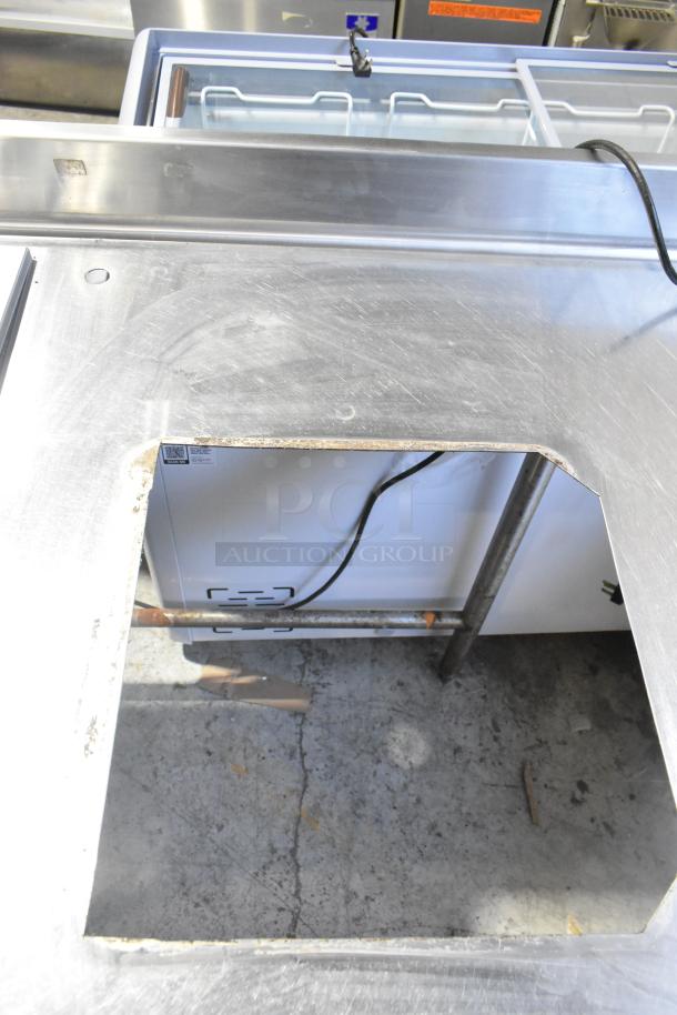 Stainless steel commercial work table with drop-in section, 115 volts, 1 phase, visible wear, electrical cord attached.