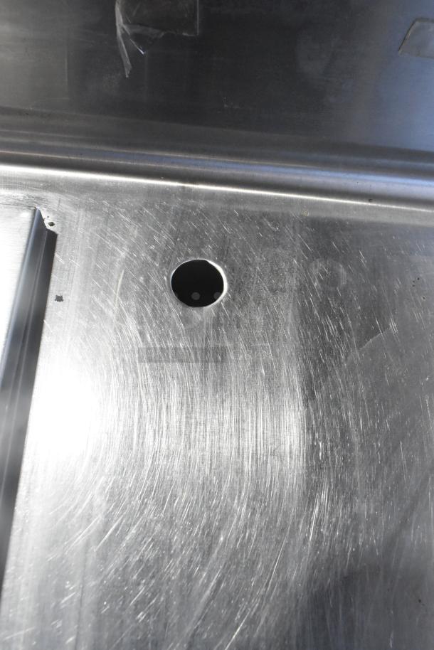 Stainless steel commercial work table with drop-in, features visible scratch marks, 115 volts, 1 phase.