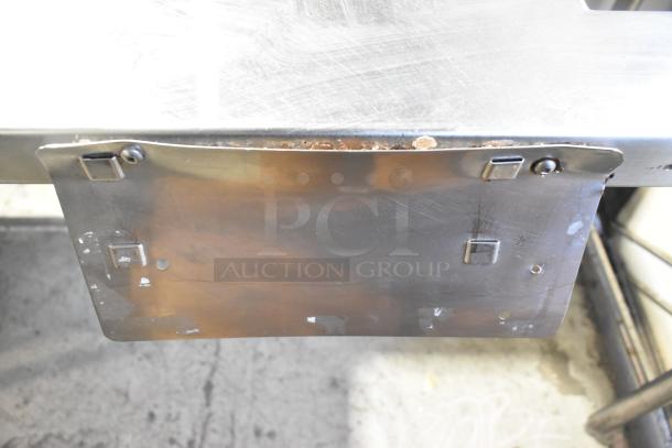 Stainless steel commercial work table with drop-in slot, 115 volts, 1 phase, minor surface wear, sturdy design.