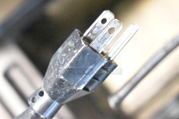 Close-up of a power plug, likely part of the Server IS-1/3 Intelliserv 6 Qt. Food Warmer. Shows three-prong configuration.
