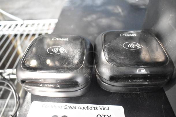 Two Toast credit card scanners, black, NFC symbol, minor surface scratches, part of a lot including POS and receipt printers.