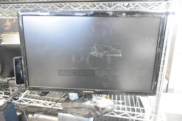 Samsung S22D300HY computer monitor on wire shelf, visible scratches on screen, dust on base. Auction includes 8 items.