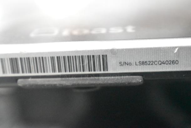 Close-up of a Toast POS monitor showing a barcode and serial number LS8522CQ40260.