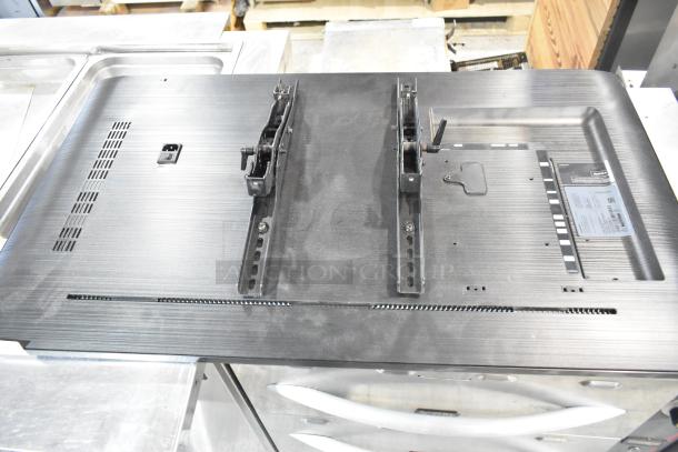 Samsung PH43F-P 43" TV back view showing mounting brackets, ventilation grilles, and label. Appears in good condition.