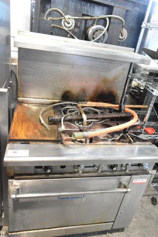 Imperial IR4-612 stainless steel commercial gas griddle with 4-burner range, oven, over shelf, and backsplash; shows wear.