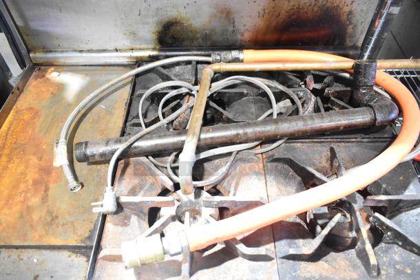 Imperial IR4-612 commercial stainless steel flat top griddle with 4-burner range, oven, over shelf, and backsplash. Rust and wear visible.