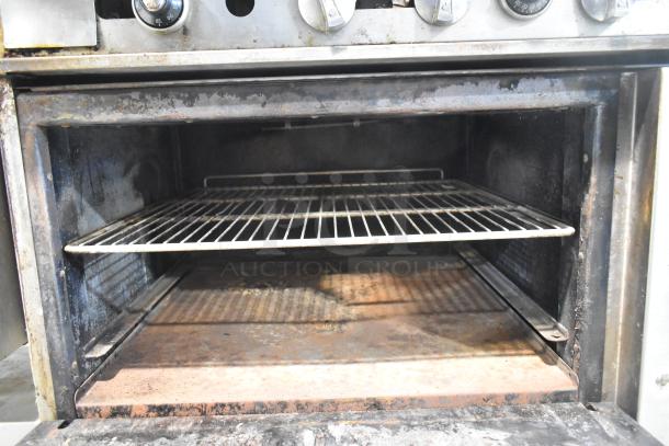 Imperial IR4-612 gas-powered griddle and range with oven, shelf, and backsplash, showing interior oven condition.