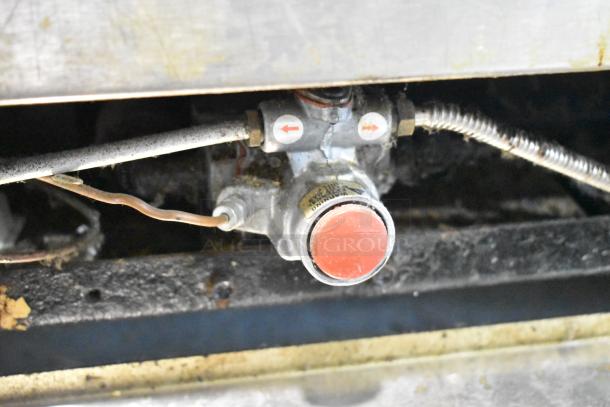 Close-up view of a gas valve connection on the Imperial IR4-612 stainless steel commercial griddle, showing signs of wear.