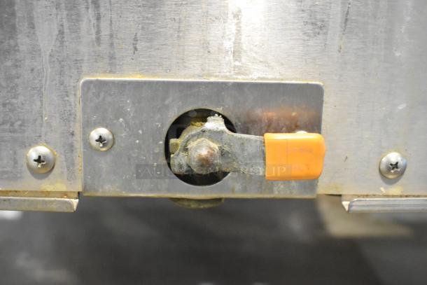 Intek Xtreme Steam XSG-5 stainless steel steam cabinet latch detail, showing moderate wear on surface and orange marking.