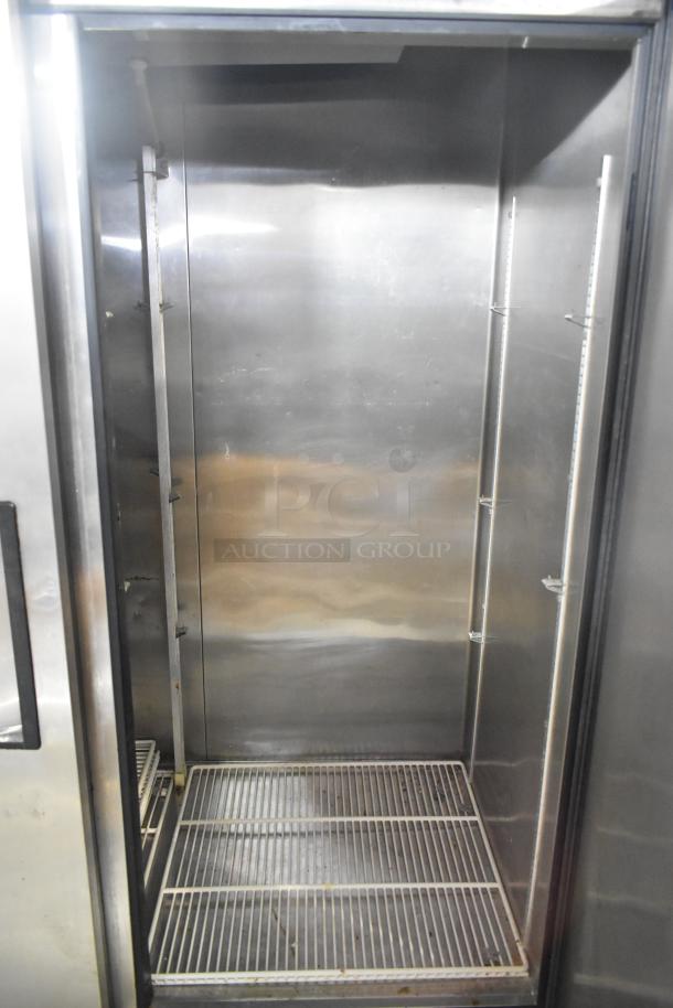 True TS-49 stainless steel commercial 2-door reach-in cooler with poly-coated racks, visible interior, 115 volts, 1 phase.