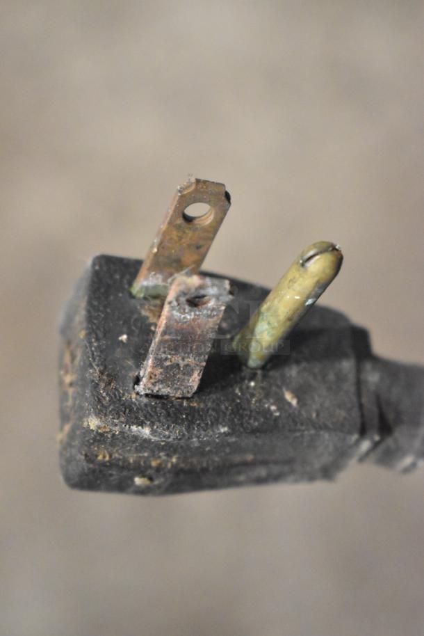 Close-up of a worn electrical plug with corrosion, belonging to a True TS-49 commercial cooler, 115 volts, 1 phase.
