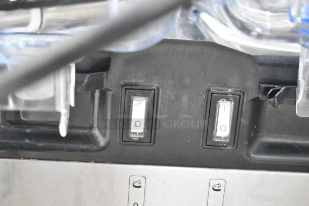 Close-up of controls on a Vollrath VBBE4-37-F beverage dispenser, showing two switches against a black panel.