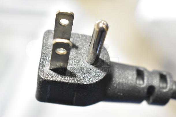 Close-up of a power plug for the Avantco 360DFF13HCL ice cream freezer, showing prongs and black housing.
