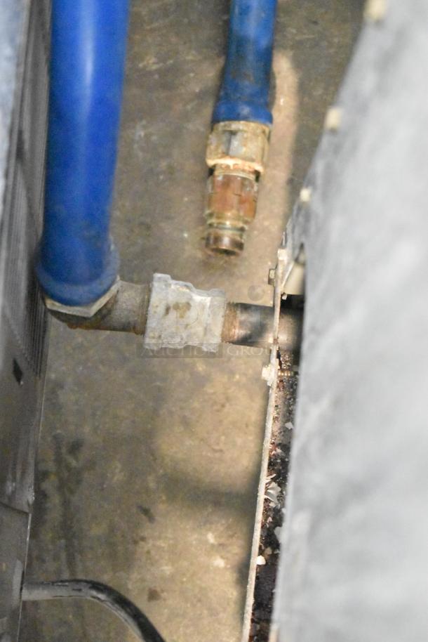 Frymaster GF40SD natural gas fryer connection detail, showing blue hose, rusted connector, stainless steel body nearby.