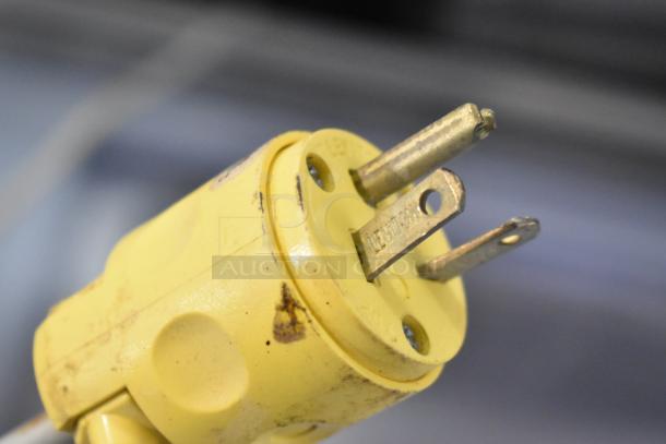 A close-up of a yellow three-pronged electrical plug for the Tecfrigo Microgel 4 Gelato Display. Some wear is visible.