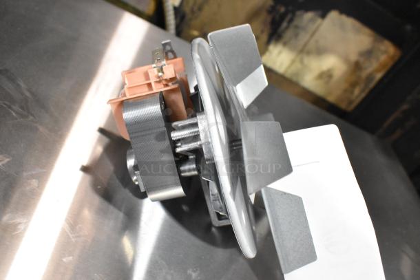 Brand new metal convection oven fan with minor scratches. Features robust metal blades and electrical connectors.