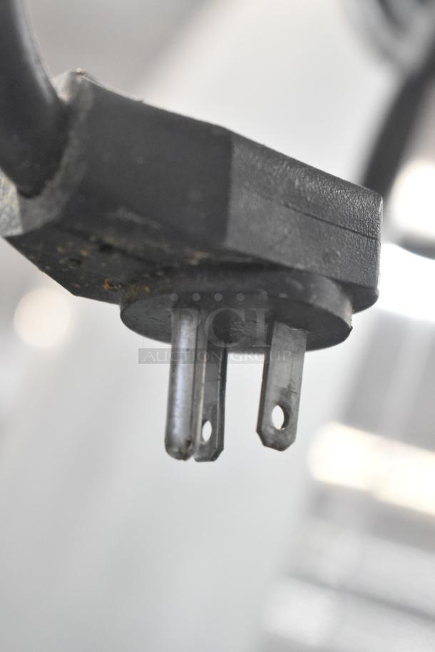 Close-up of a 3-prong plug for a True TA1DT-2HS stainless steel commercial cooler, 115 volts, 1 phase.