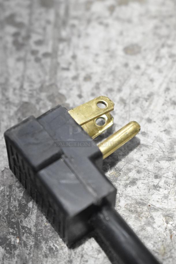 Close-up of a power plug for the Beverage Air SPE72HC-30M sandwich prep table, showing brass prongs and black casing.
