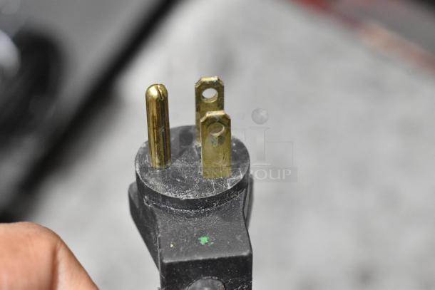 Close-up image of a three-prong electrical plug, compatible with the 2021 Delfield 406P-STAR4 undercounter cooler.