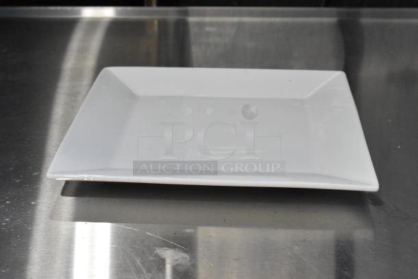 Acopa white ceramic plate with slight scratches, new condition, square shape, smooth finish.