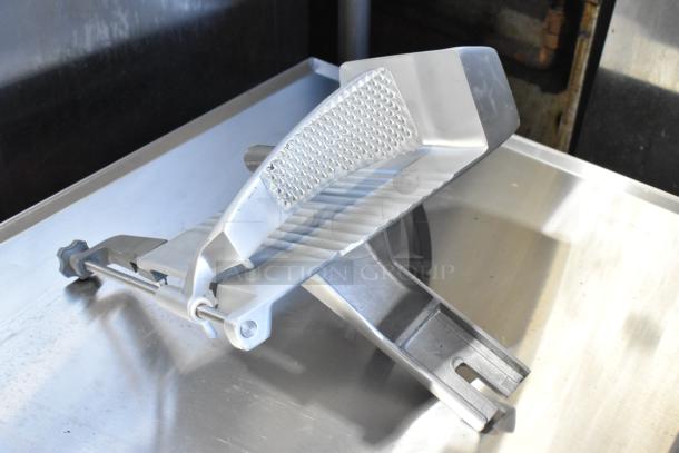 Brand new metal carriage for meat slicer, commercial grade, with slight scratches and dents, textured grip, durable construction.