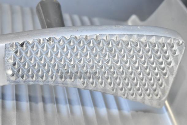 Brand new metal commercial carriage for meat slicer with textured grip surface. Scratch and dent condition.