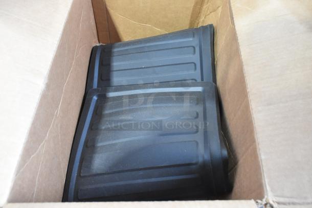 Box containing new Escalaade Mats; black, ribbed design, minimal scratches visible. Part of 2-item auction lot.